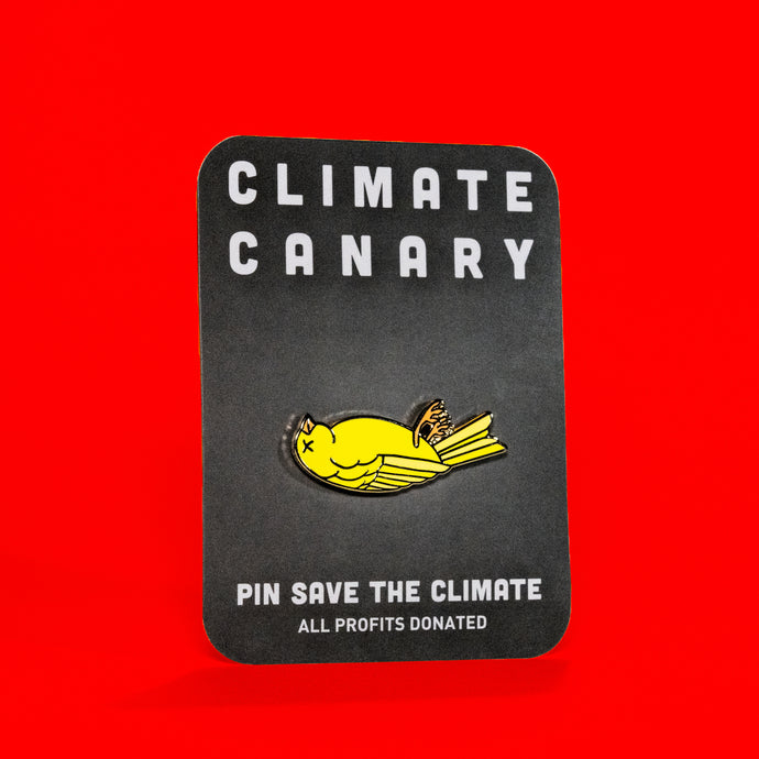 picture of an enamel pin on a card. the enamel pin features an illustration of a dead yellow canary laying on it's back with an 